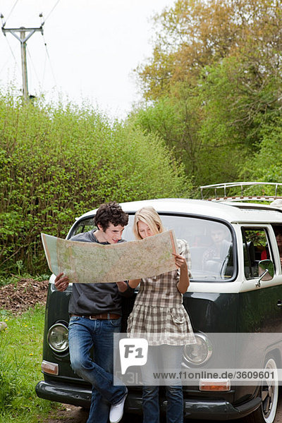Junges Paar mit dem Wohnmobil auf der Karte