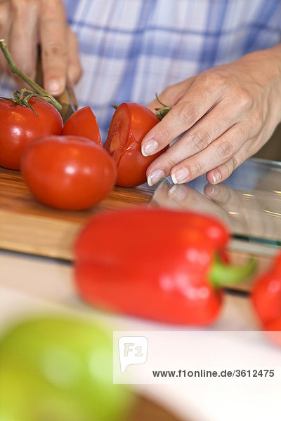 Frau schneidet Tomaten in der Küche  close-up