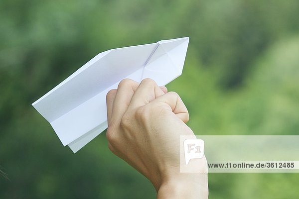 Hand hält Papierflugzeug  close-up