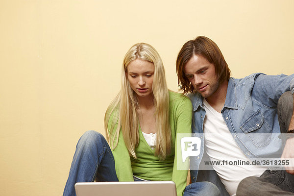 Junges Paar benutzt einen Laptop