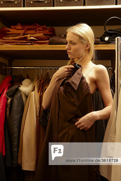 Junge Frau sucht eine Bluse aus dem Kleiderschrank aus