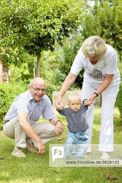 Großeltern mit Kleinkind im Garten
