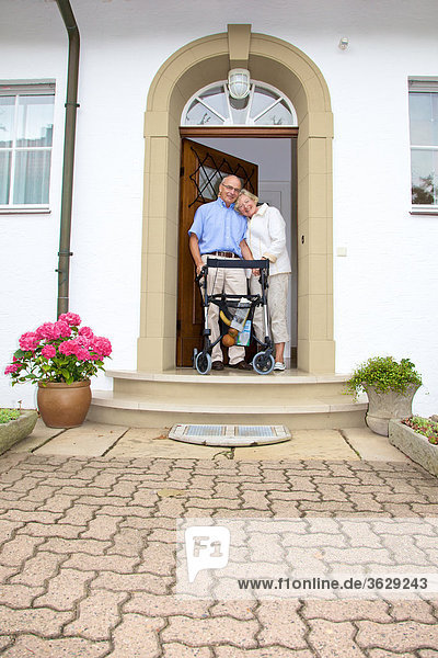 Seniorenpaar mit Rollator an der Eingangstür