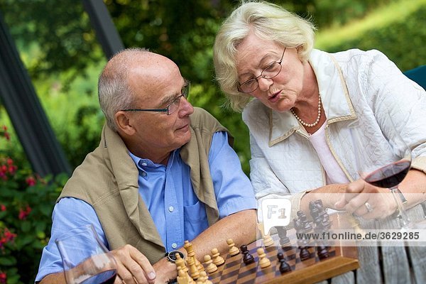 Senior couple on terrace playing chess