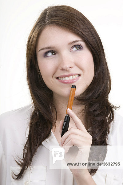 Smiling young woman with a pen in her hand