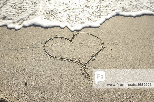 Herz-Symbol in nassem Sand
