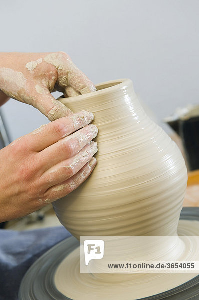 Keramikerin arbeitet in ihrer Werkstatt auf der Töpferscheibe  Drehen einer Vase  Geisenhausen  Bayern  Deutschland  Europa