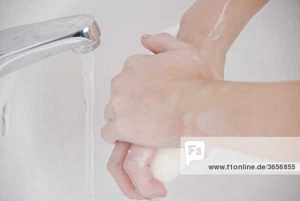 Frau wäscht Hände mit Seife
