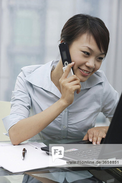 Eine junge Frau telefoniert im Büro