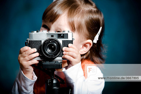 Kleines Mädchen mit alter Fotokamera