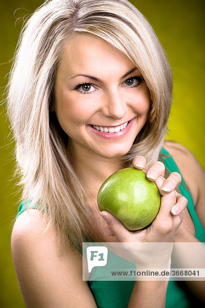 Junge Frau mit grünem Apfel