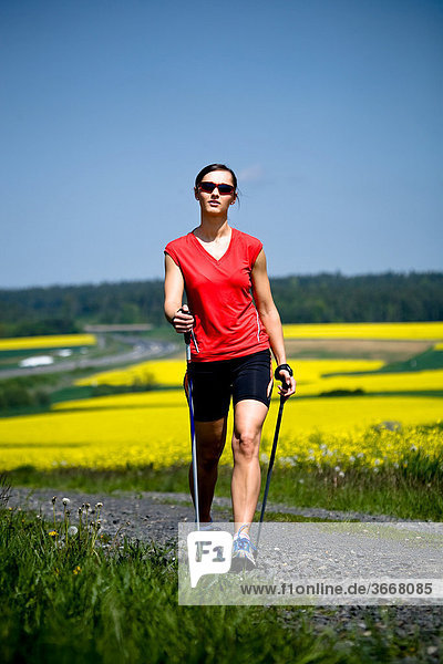 Junge Frau beim Nordic Walking