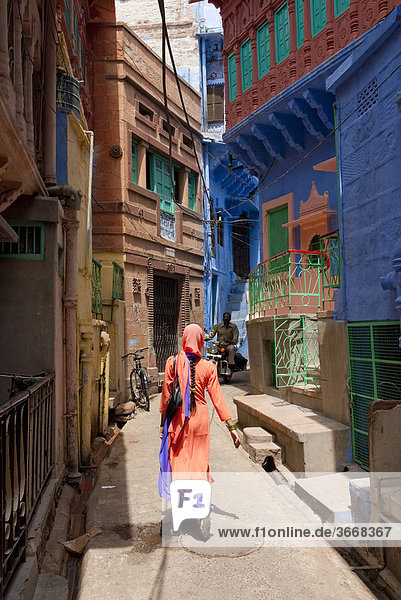 Indian woman walking down a lane  Sari  Jodphur  Rajasthan  India  Asia