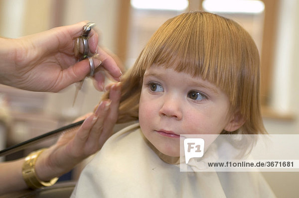 Kind beim Friseur Haarschnitt Haare schneiden