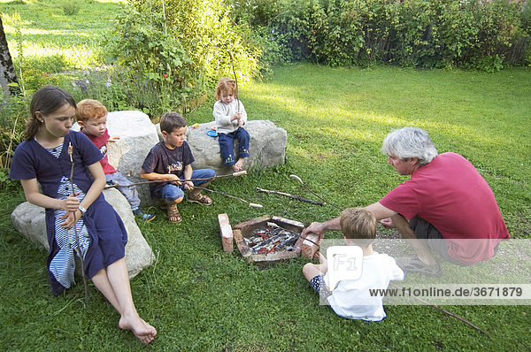 Familiy having a barbecue at an open fire place campfire