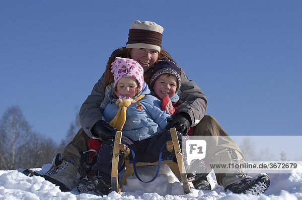 Familiy in the winter sleigh sledging on a sledge