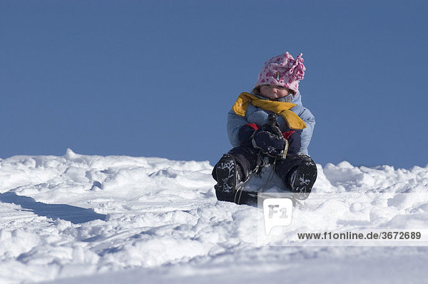 Kind im Winter beim Schlitten fahren
