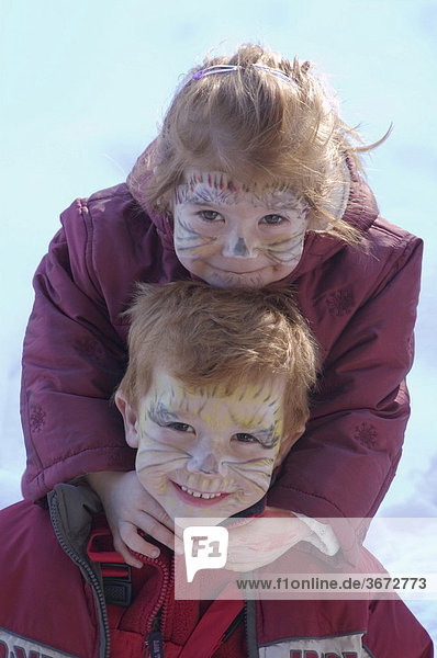 Zwei Kinder mit Katzen Gesichtern geschminkt für Fasching Kinderschminke