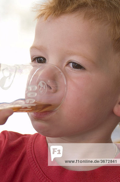 Junge trinkt aus einem Glas