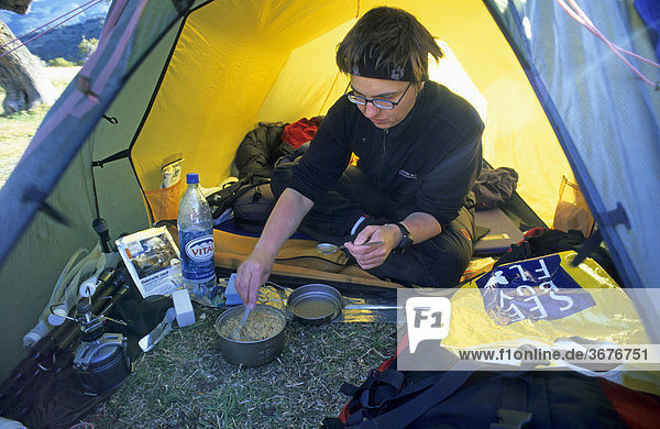 Bergsteigerin kocht vor dem Zelt Patagonien Chile