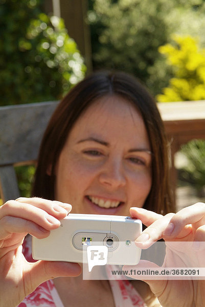 Woman photographs with photo mobile phone