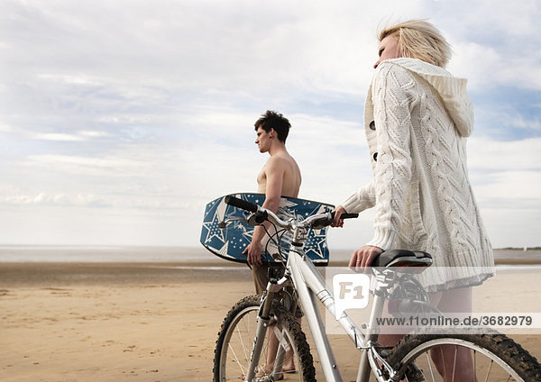 Paar am Strand mit Bike & Boogie Board