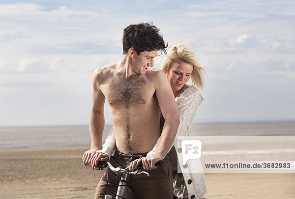 Paar am Strand auf dem Fahrrad