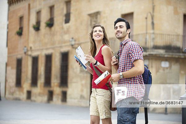 Paar mit Reiseführern auf dem Stadtplatz