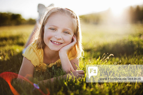 Junges Mädchen im Gras lächelnd