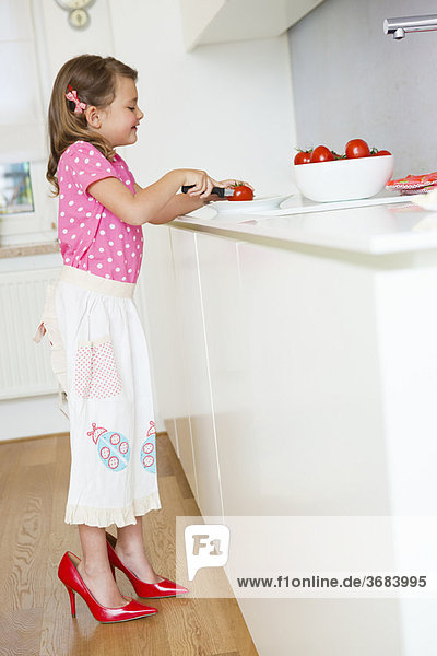 Girl cutting tomatoes in high heels