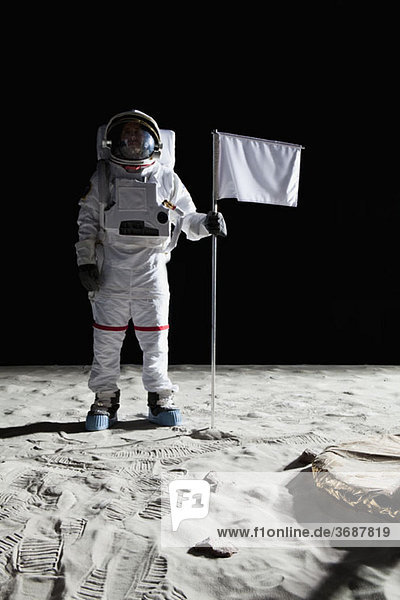 Ein Astronaut steht neben einer weißen Fahne.