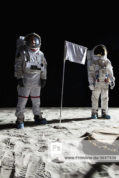 Zwei Astronauten auf dem Mond  dazwischen eine weiße Fahne.