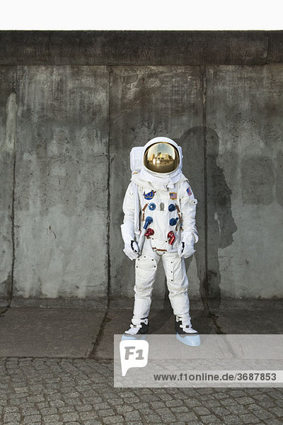 Ein Astronaut steht auf einem Bürgersteig in einer Stadt.