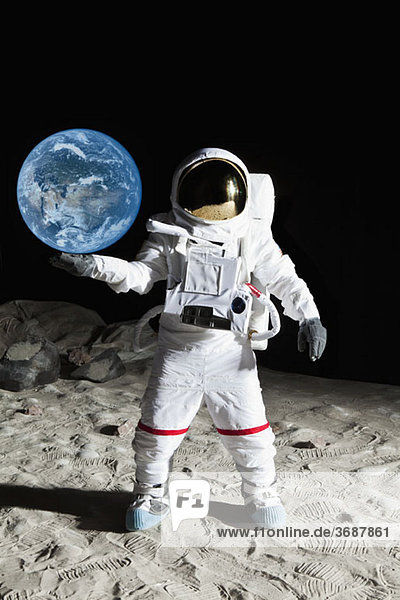 An astronaut on the moon's surface pretending to hold the earth