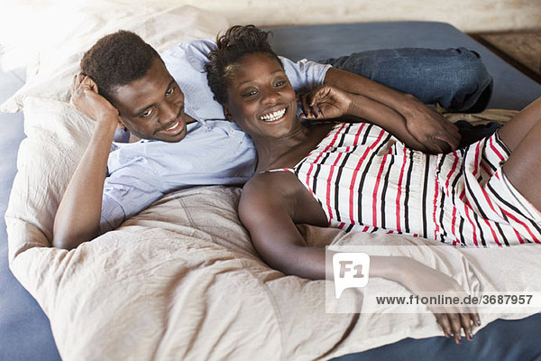 Ein junges Paar entspannt im Bett