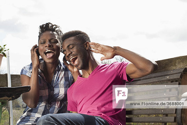 A young couple listening to headphones and singing