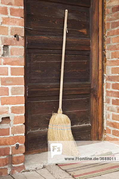 A broom leaning against a door