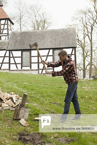 A man chopping wood in a rural setting