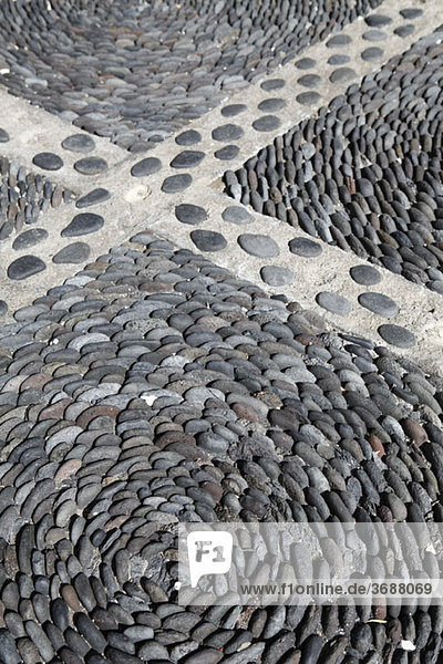 Detail von Steinen  die in einem Muster auf dem Boden angeordnet sind.