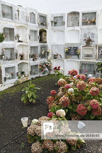 Ein Garten und gestapelte Gräber auf einem Friedhof