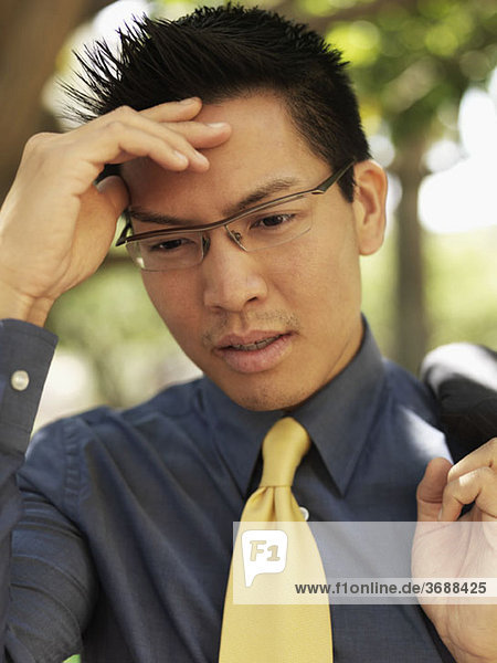 A businessman holding his forehead and grimacing