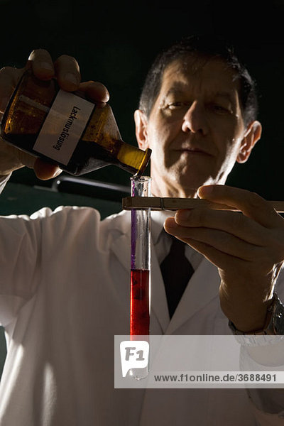 Ein Wissenschaftler gießt Flüssigkeit in ein Reagenzglas.