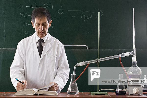 Ein Chemielehrer  der ein Experiment in einem Klassenzimmer durchführt.