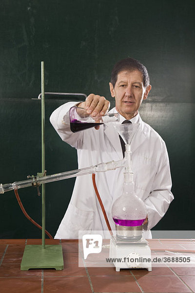 Ein Chemielehrer  der ein Experiment in einem Klassenzimmer durchführt.