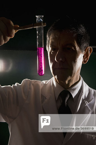 A scientist looking at a test tube of liquid