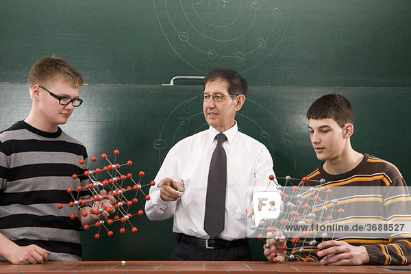 Ein Lehrer zeigt den Schülern molekulare Strukturmodelle.