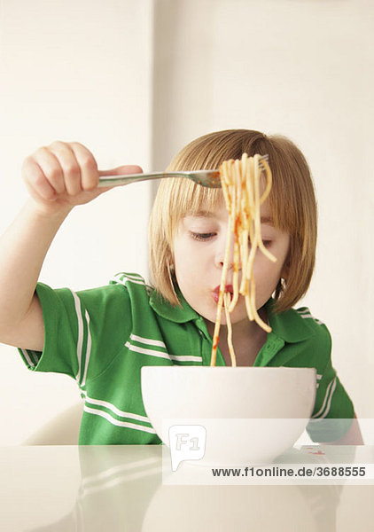 Ein Junge  der Spaghetti isst.