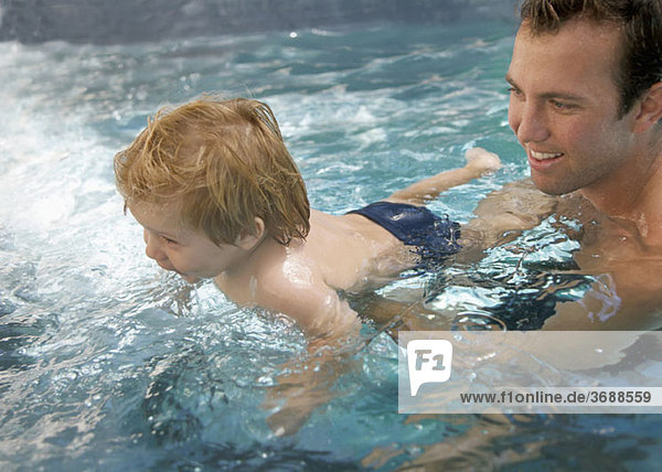 Ein Mann und ein kleiner Junge in einem Schwimmbad