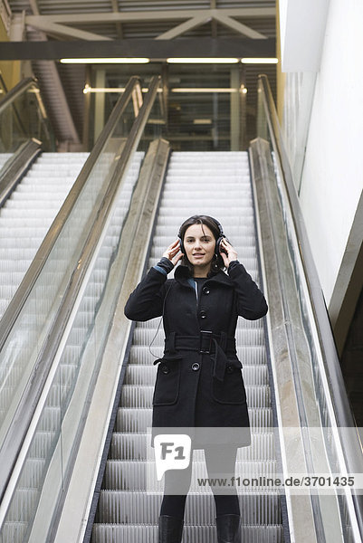 Frau mit Kopfhörern in der U-Bahn