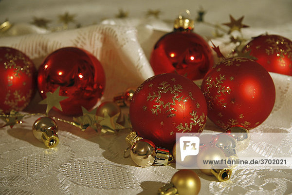 Rote Baumkugeln mit Girlanden auf Weihnachtsdecke  Weihnachtsdekoration